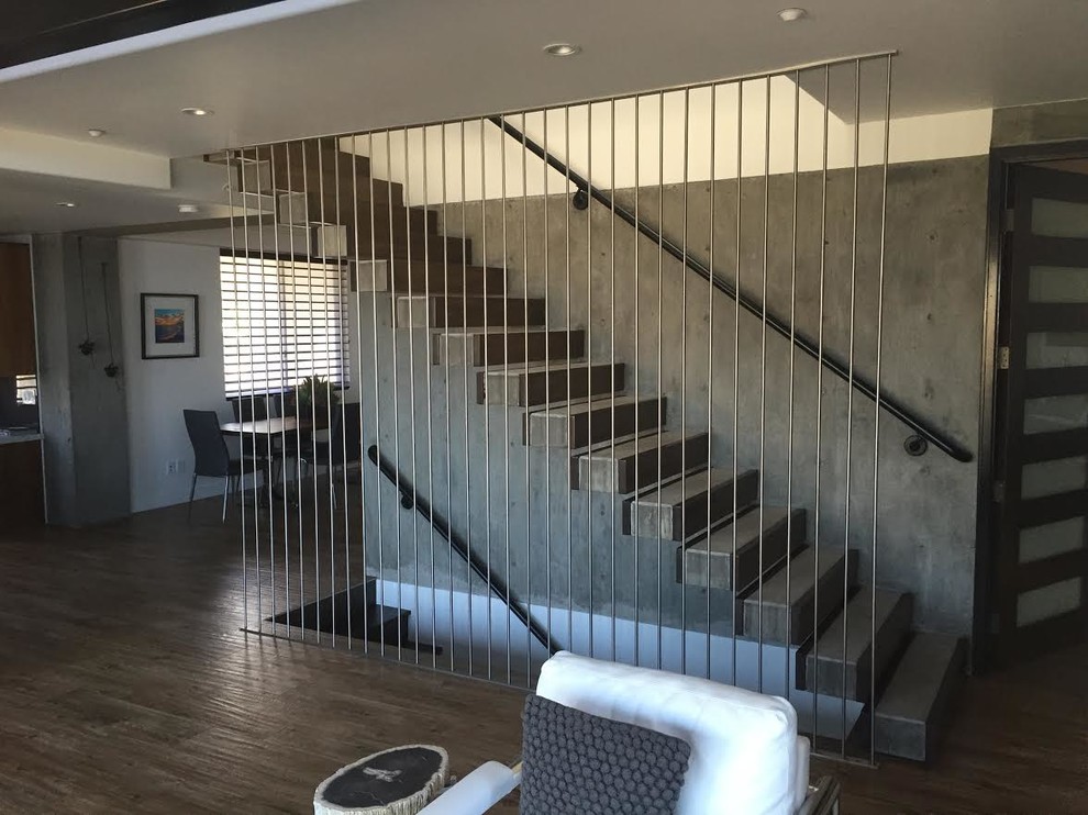 Large modern concrete straight staircase in Orange County with concrete risers.
