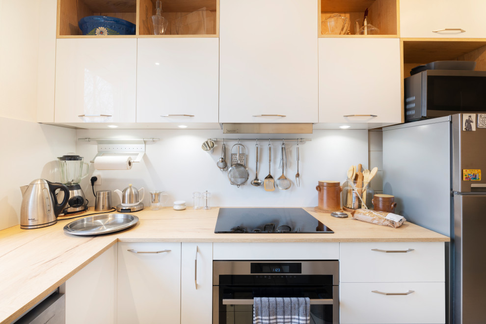 Design ideas for a small contemporary l-shaped enclosed kitchen in Nancy with white cabinets, laminate countertops, white splashback and a breakfast bar.