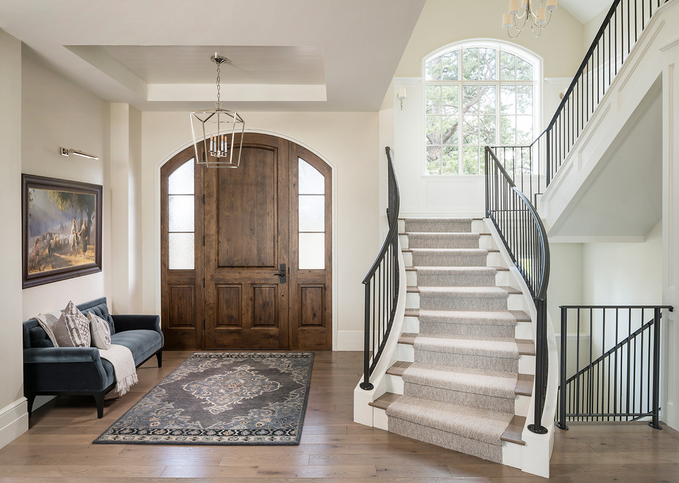 Example of a transitional medium tone wood floor and brown floor foyer design in Denver with beige walls and a medium wood front door