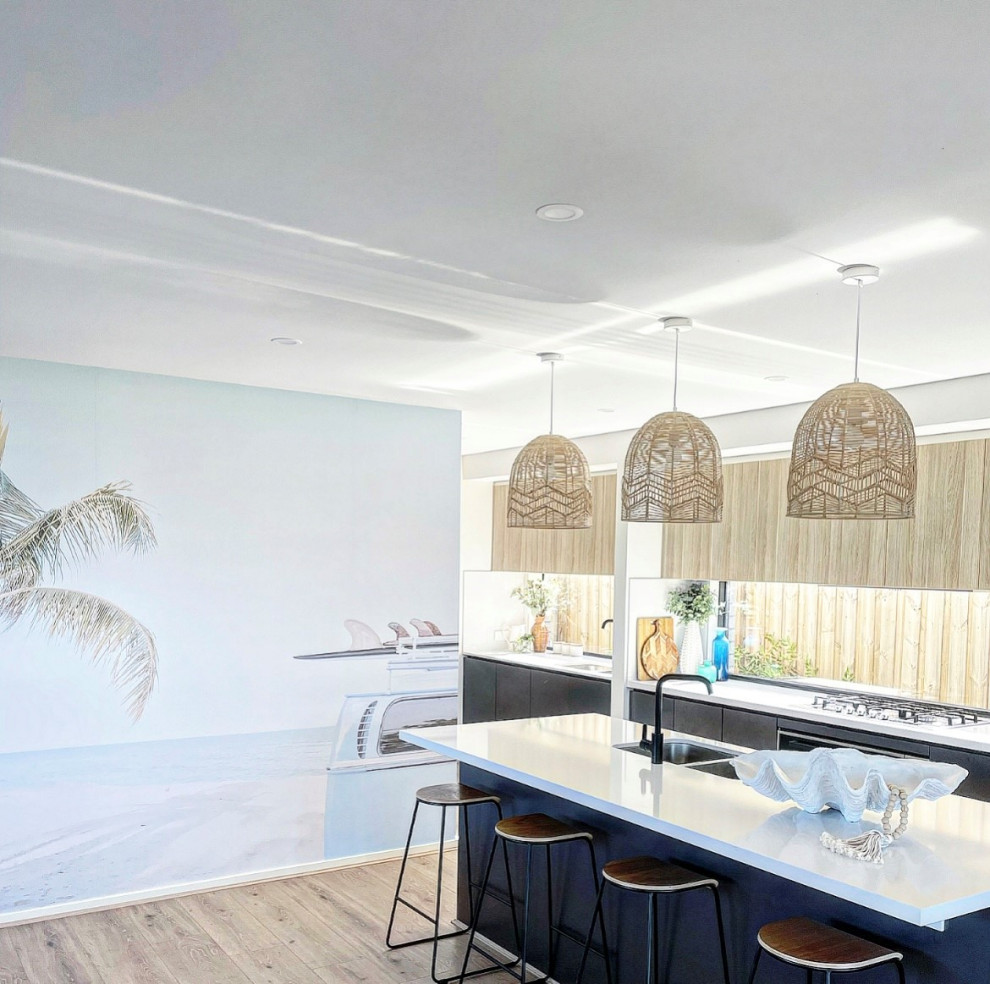 Inspiration for a large coastal galley open plan kitchen in Geelong with a submerged sink, light wood cabinets, engineered stone countertops, window splashback, stainless steel appliances, vinyl flooring, an island and white worktops.