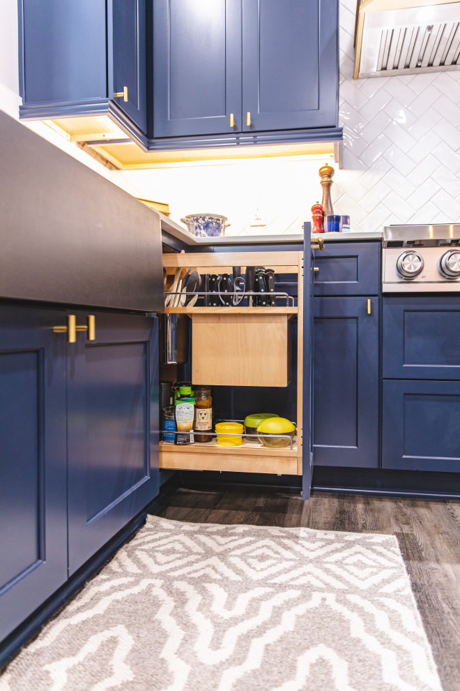 ワシントンD.C.にある高級な中くらいなトランジショナルスタイルのおしゃれなキッチン (エプロンフロントシンク、落し込みパネル扉のキャビネット、青いキャビネット、クオーツストーンカウンター、白いキッチンパネル、サブウェイタイルのキッチンパネル、シルバーの調理設備、グレーの床、白いキッチンカウンター) の写真