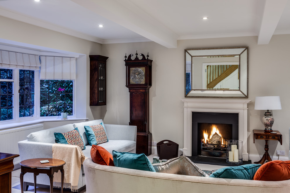 This is an example of a contemporary formal enclosed living room in Surrey with beige walls, carpet, a standard fireplace, a stone fireplace surround and no tv.