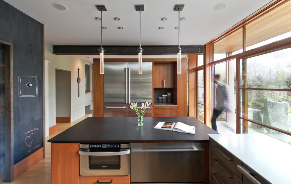 Design ideas for a mid-sized modern u-shaped separate kitchen in Seattle with flat-panel cabinets, medium wood cabinets, stainless steel appliances, light hardwood floors, with island, a farmhouse sink, white splashback and subway tile splashback.
