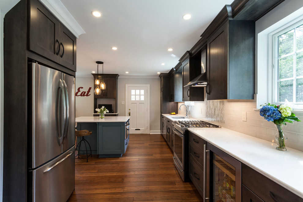 Mid-sized transitional bamboo floor eat-in kitchen photo with an undermount sink, shaker cabinets, dark wood cabinets, quartz countertops, gray backsplash, ceramic backsplash, stainless steel appliances and an island