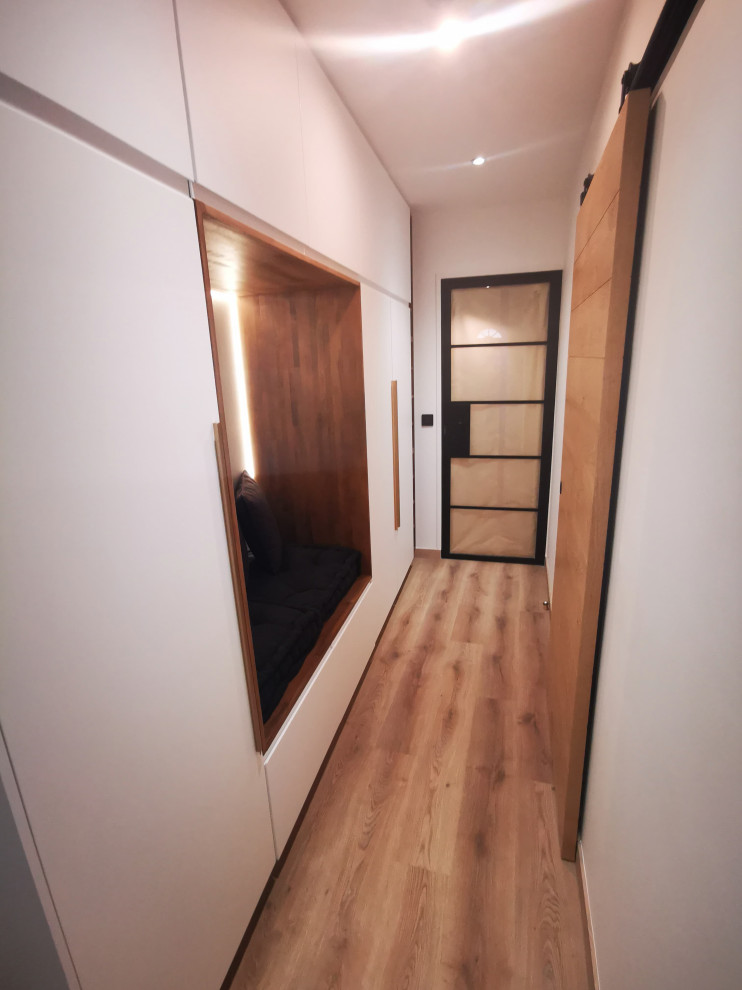 Modelo de armario minimalista extra grande con puertas de armario blancas, suelo vinílico y suelo marrón