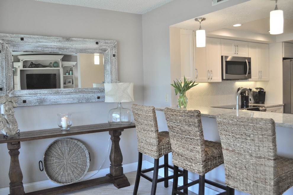 Mid-sized transitional u-shaped eat-in kitchen photo with an undermount sink, shaker cabinets, white cabinets, quartz countertops, white backsplash, marble backsplash, stainless steel appliances and no island