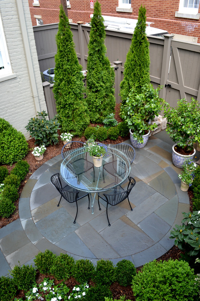 This is an example of a small traditional backyard patio in DC Metro with natural stone pavers.