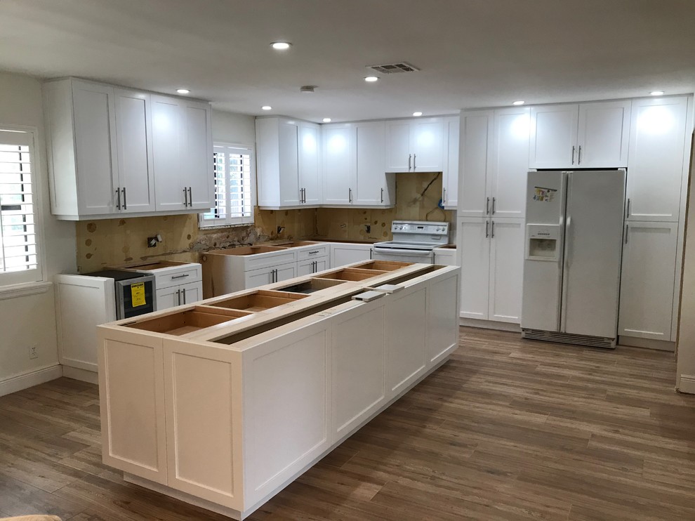 Large modern l-shaped kitchen pantry in Miami with shaker cabinets, white cabinets and with island.