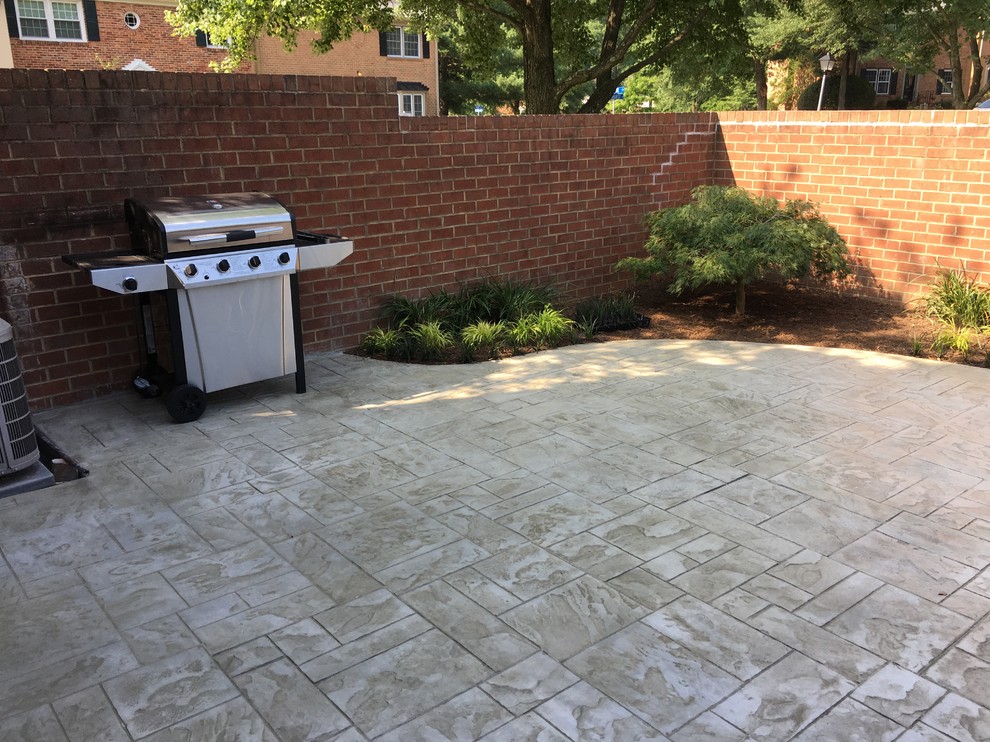 Design ideas for a small asian backyard patio in DC Metro with stamped concrete.