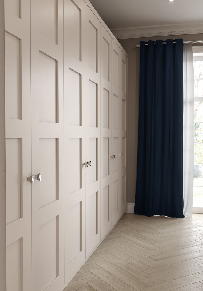 Photo of a mid-sized traditional built-in wardrobe in Manchester with shaker cabinets, grey cabinets, medium hardwood floors and brown floor.