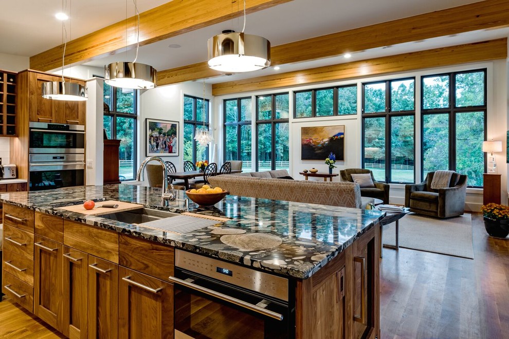 Example of a large transitional l-shaped medium tone wood floor and brown floor open concept kitchen design with an undermount sink, shaker cabinets, dark wood cabinets, granite countertops, white backsplash, glass tile backsplash, stainless steel appliances and an island