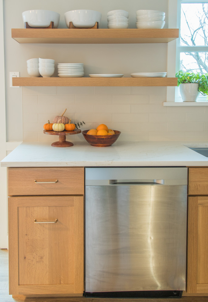 Example of a mid-sized transitional u-shaped light wood floor and brown floor eat-in kitchen design with shaker cabinets, white cabinets, white backsplash, subway tile backsplash, no island and white countertops