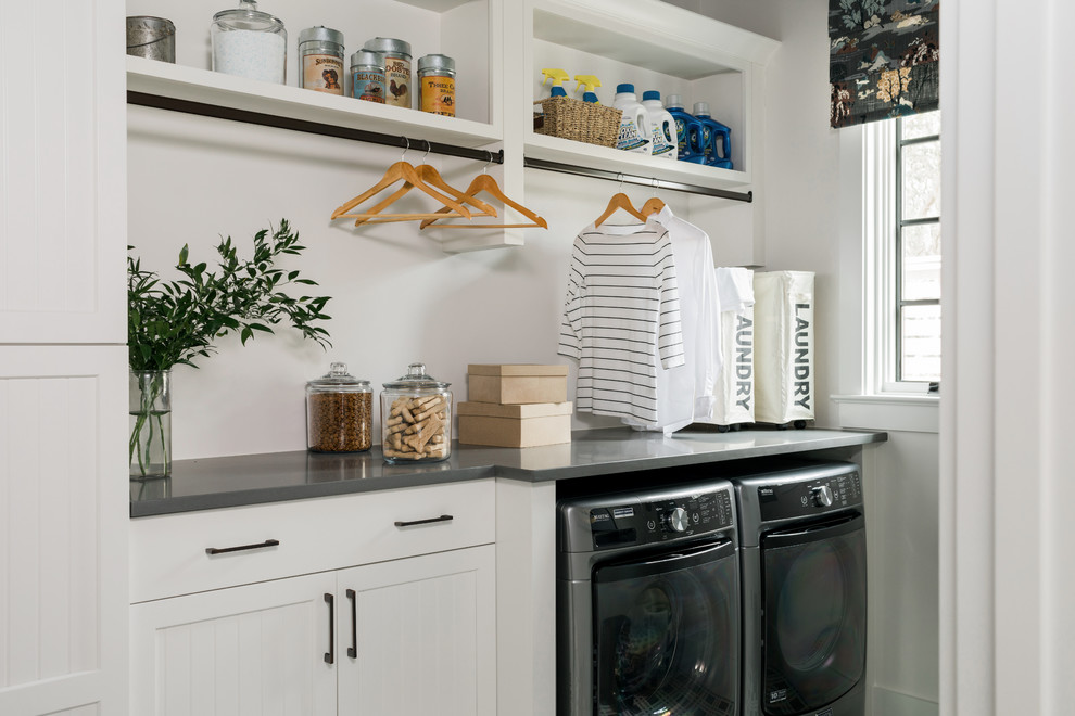 Inspiration for a small transitional dedicated laundry room in Chicago with white cabinets, white walls, an integrated washer and dryer and grey benchtop.