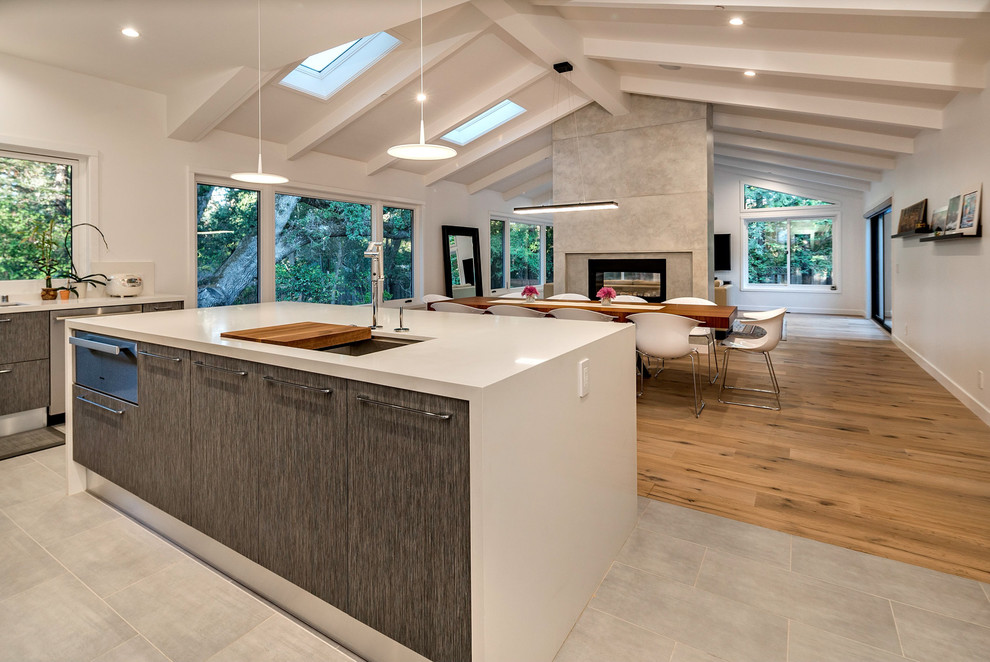 Inspiration for a large contemporary u-shaped open plan kitchen in San Francisco with a drop-in sink, flat-panel cabinets, dark wood cabinets, quartz benchtops, white splashback, stainless steel appliances, with island, ceramic floors and grey floor.