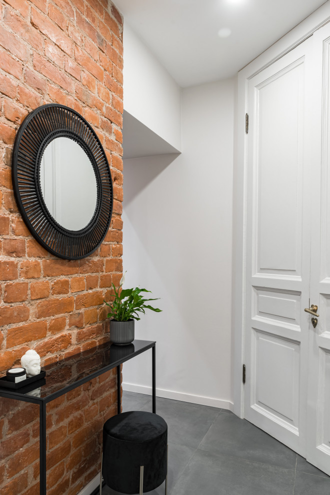 Inspiration for a small industrial entry hall in Saint Petersburg with white walls, porcelain floors, a single front door, a gray front door, grey floor and brick walls.