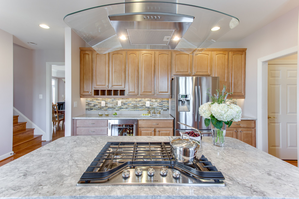 Inspiration for a mid-sized transitional u-shaped kitchen in Baltimore with an undermount sink, raised-panel cabinets, medium wood cabinets, granite benchtops, glass sheet splashback, stainless steel appliances, medium hardwood floors and with island.