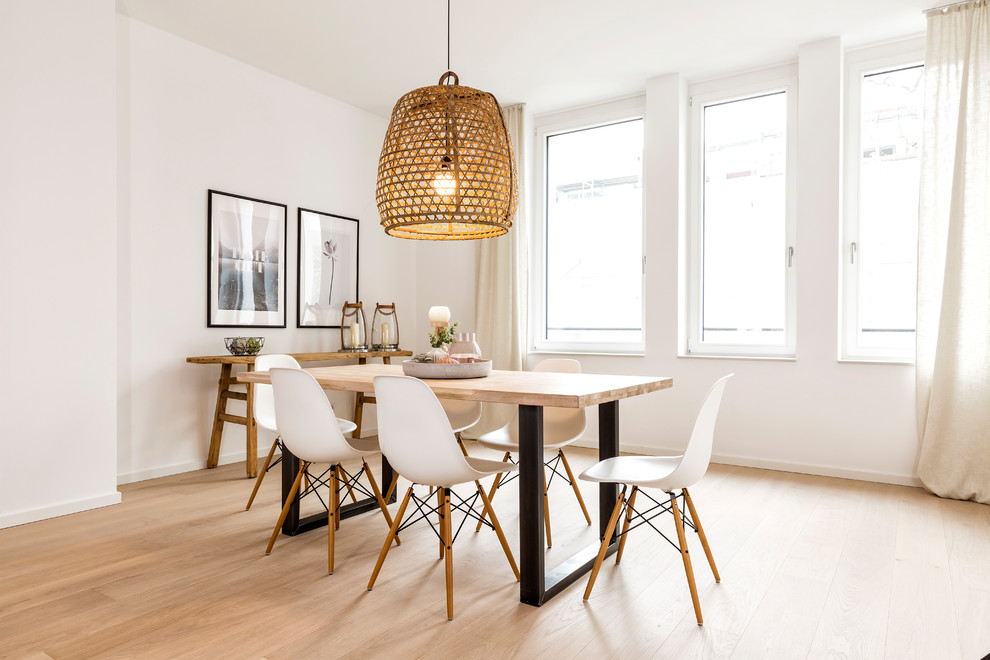 Mid-sized scandinavian separate dining room in Hamburg with white walls, light hardwood floors, brown floor and no fireplace.