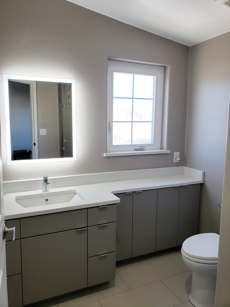 Photo of a mid-sized contemporary master bathroom in Phoenix with flat-panel cabinets, grey cabinets, a corner shower, multi-coloured tile, glass sheet wall, an undermount sink, quartzite benchtops, a hinged shower door and white benchtops.