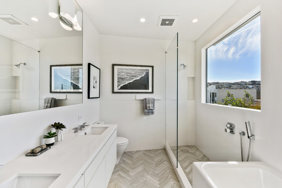 Design ideas for a contemporary master wet room bathroom in San Francisco with flat-panel cabinets, white cabinets, a corner tub, a one-piece toilet, white tile, white walls, an undermount sink, grey floor and an open shower.