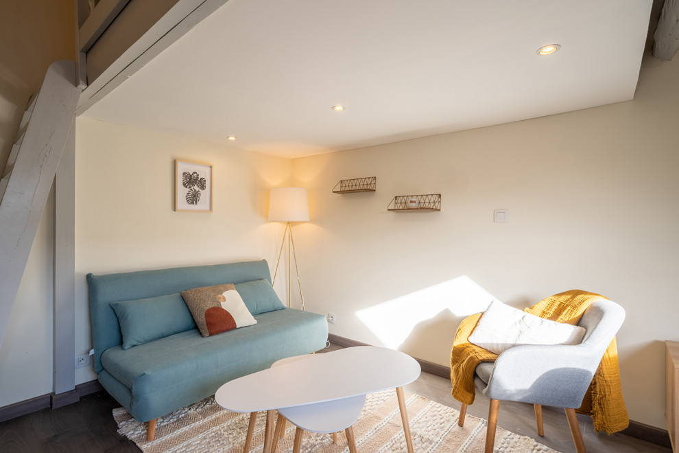 This is an example of a small contemporary grey and white mezzanine living room in Nantes with beige walls, medium hardwood flooring, no fireplace, a wall mounted tv, grey floors and exposed beams.