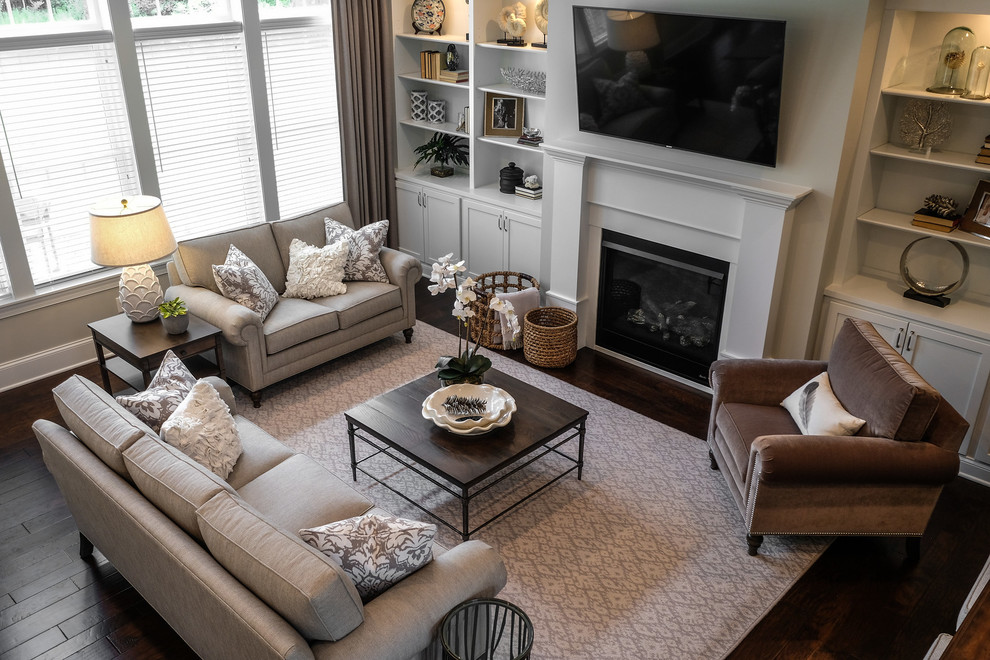 Mid-sized transitional open concept family room in Detroit with grey walls, dark hardwood floors, a standard fireplace, a wood fireplace surround, a wall-mounted tv and brown floor.