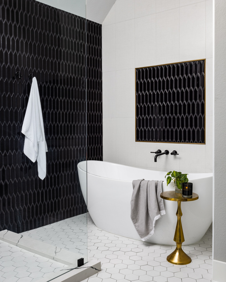 Klassisk inredning av ett en-suite badrum, med ett fristående badkar, svart kakel och vitt golv