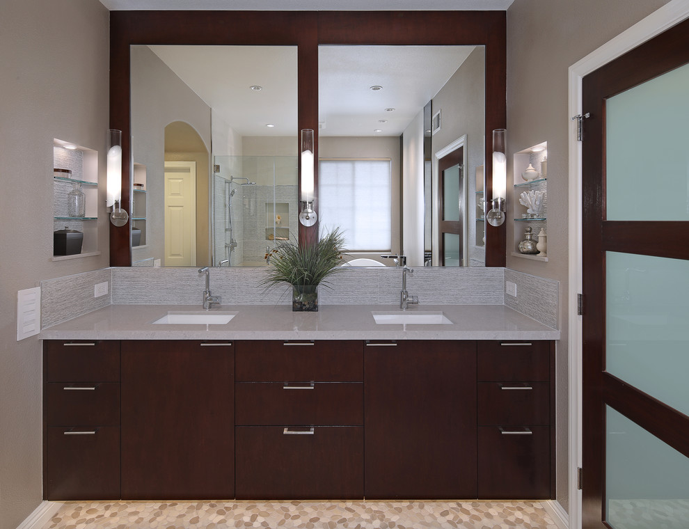 Inspiration for a large contemporary master bathroom in Orange County with flat-panel cabinets, dark wood cabinets, a freestanding tub, a corner shower, grey walls, porcelain floors, an undermount sink, granite benchtops, grey floor and a hinged shower door.