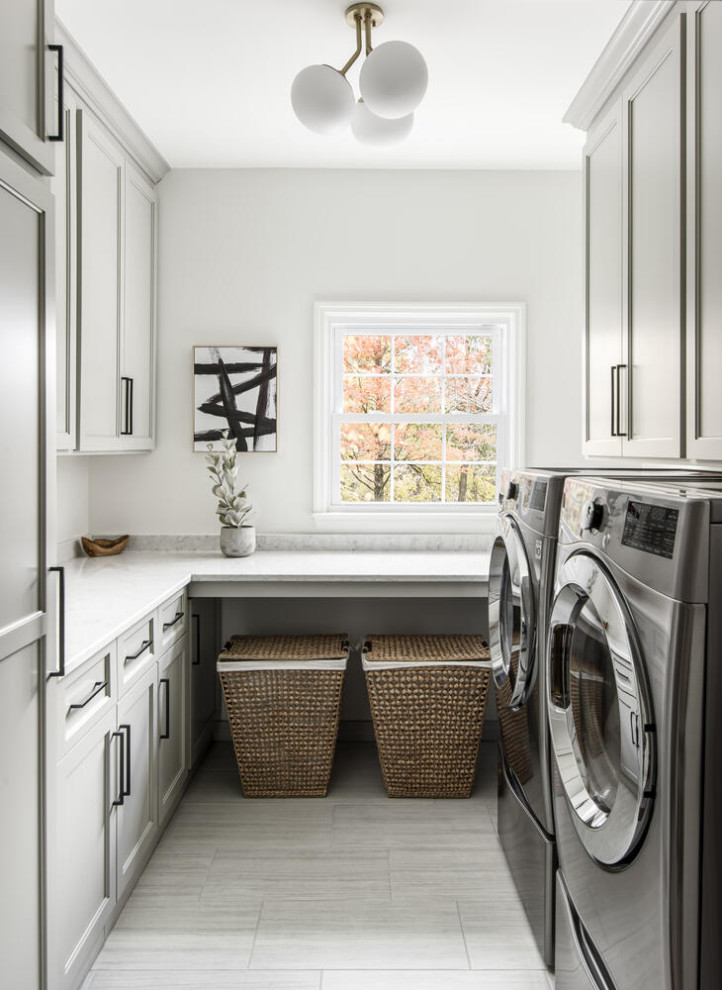 Design ideas for a mid-sized transitional u-shaped dedicated laundry room in Nashville with shaker cabinets, quartz benchtops, engineered quartz splashback, medium hardwood floors, a side-by-side washer and dryer and white benchtop.