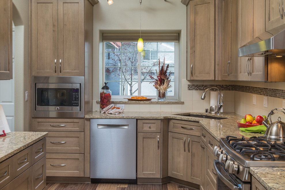 Mid-sized transitional galley medium tone wood floor eat-in kitchen photo with an undermount sink, recessed-panel cabinets, gray cabinets, quartz countertops, beige backsplash, ceramic backsplash, stainless steel appliances and no island