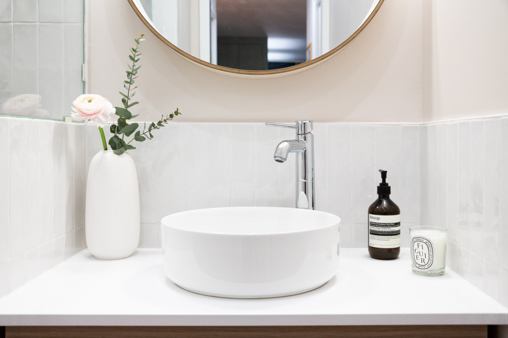 Exempel på ett litet maritimt vit vitt badrum med dusch, med luckor med infälld panel, skåp i ljust trä, en kantlös dusch, vit kakel, porslinskakel, rosa väggar, klinkergolv i keramik, ett konsol handfat, bänkskiva i akrylsten, orange golv och med dusch som är öppen