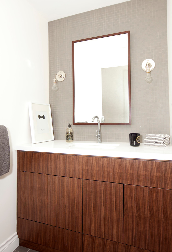 This is an example of a transitional bathroom in Vancouver with an undermount sink, flat-panel cabinets, dark wood cabinets, gray tile, mosaic tile and white walls.