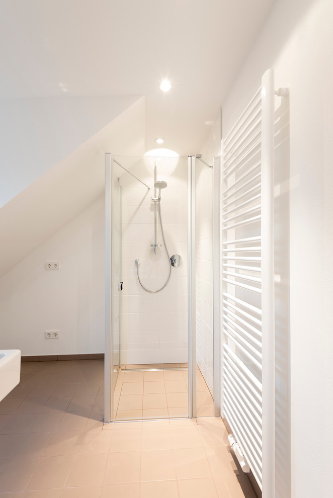 Photo of a mid-sized contemporary 3/4 bathroom in Nuremberg with a corner shower, white tile, ceramic tile, white walls and ceramic floors.