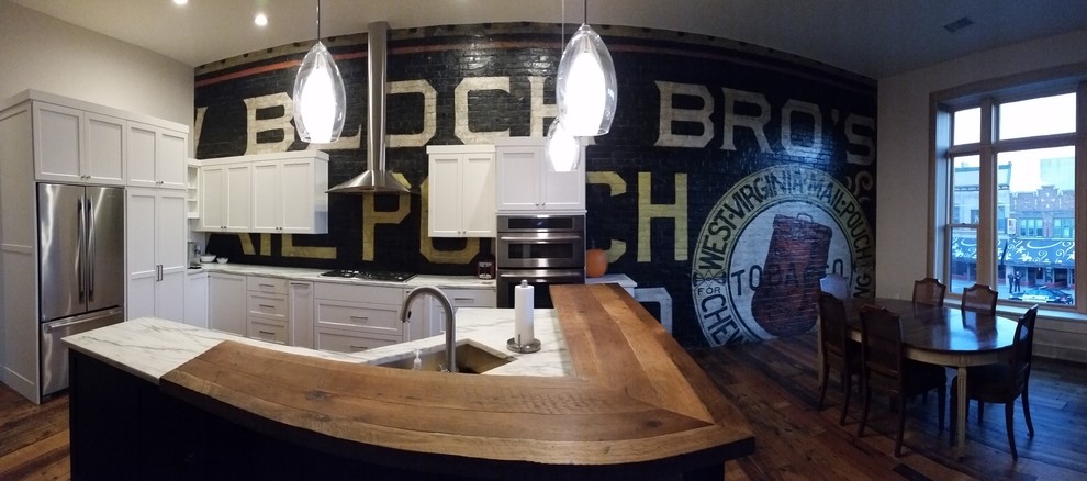 Inspiration for a large transitional single-wall medium tone wood floor eat-in kitchen remodel in Milwaukee with an undermount sink, white cabinets, marble countertops, stainless steel appliances and an island