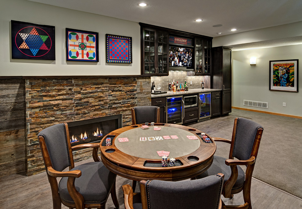 This is an example of a mid-sized transitional walk-out basement in Minneapolis with grey walls, carpet, a stone fireplace surround and a ribbon fireplace.