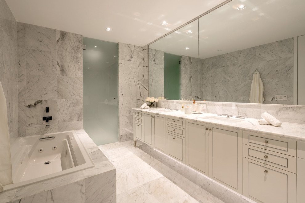 This is an example of a large master bathroom in Miami with a hot tub, marble and marble benchtops.