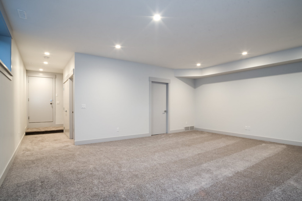 Carpeted and beige floor basement photo in Calgary with white walls