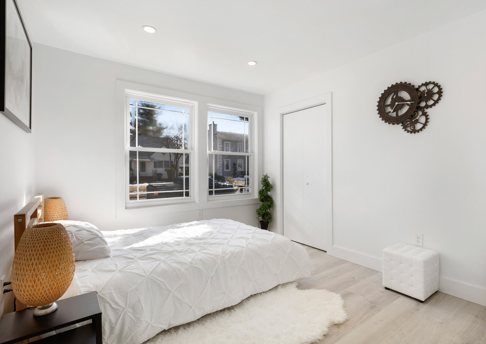 Modern Residential Construction - Mid-sized minimalist guest light wood floor, brown floor, shiplap ceiling and wall paneling bedroom photo in Newark with white walls