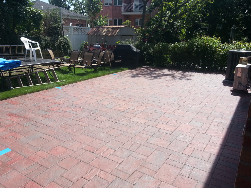 Photo of a large contemporary front yard patio in New York with concrete pavers.
