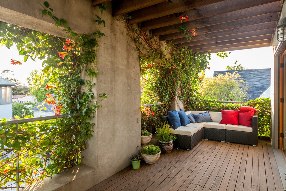 This is an example of a mid-sized mediterranean backyard deck in Los Angeles with a pergola and a vertical garden.