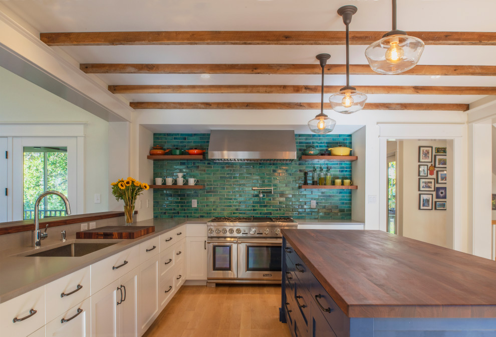 Arts and crafts l-shaped kitchen in DC Metro with an undermount sink, shaker cabinets, white cabinets, green splashback, stainless steel appliances, medium hardwood floors, with island, brown floor, grey benchtop and exposed beam.