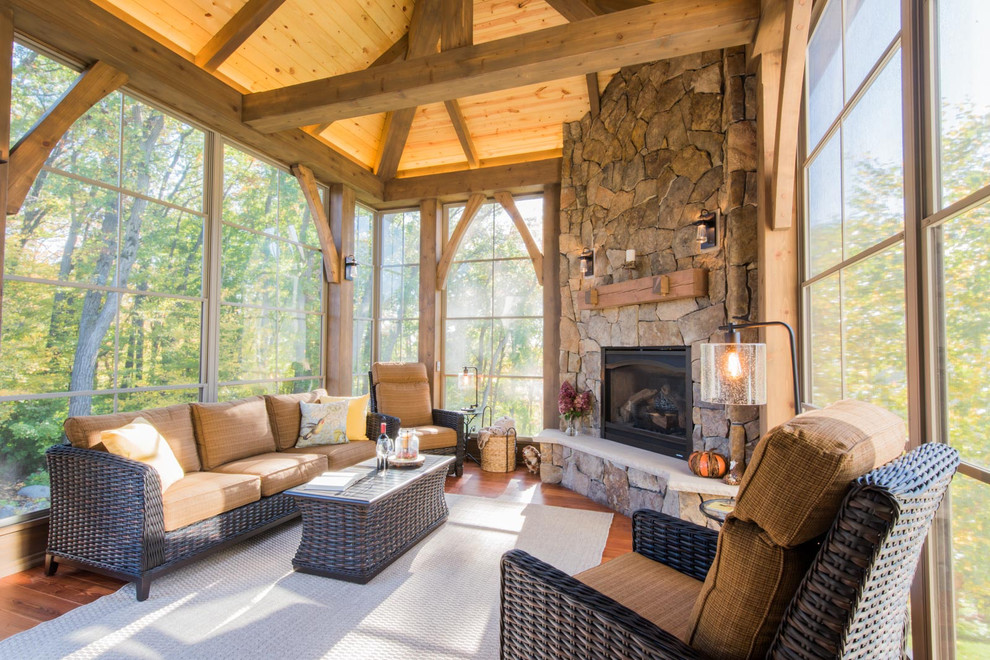 Large mountain style stone screened-in back porch photo in Minneapolis with a roof extension