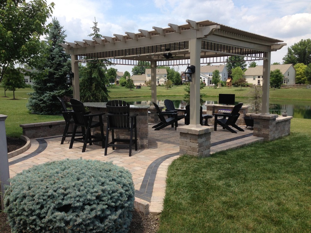 Large arts and crafts backyard patio in Cleveland with brick pavers, a gazebo/cabana and a water feature.