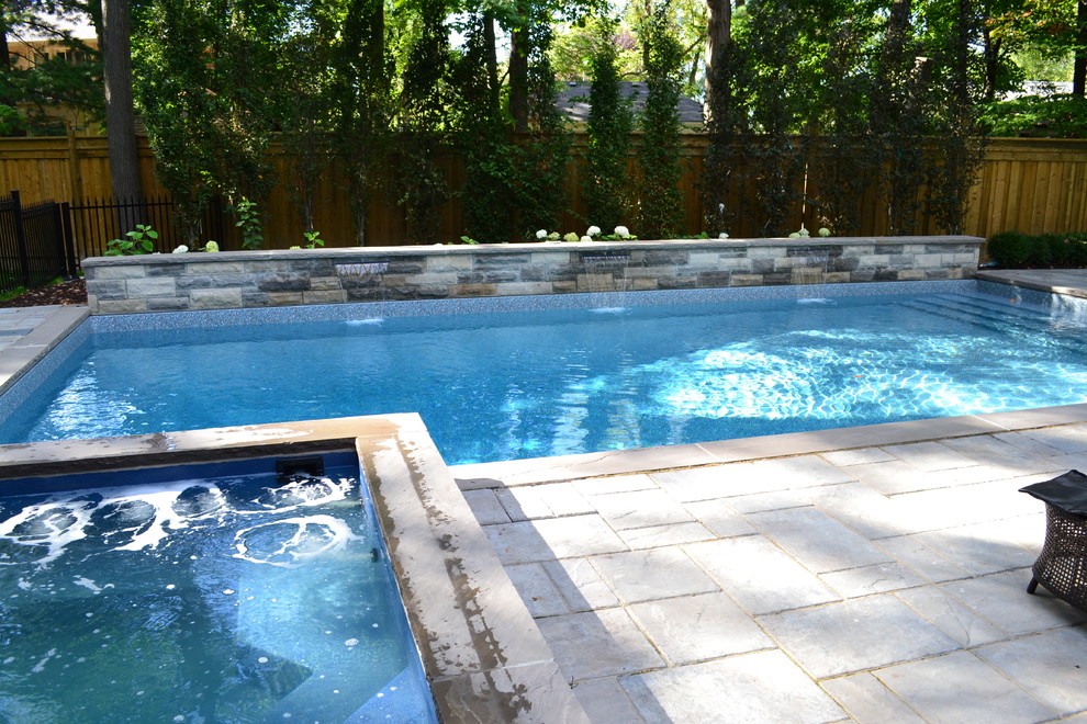Example of a large transitional backyard tile and rectangular lap hot tub design in Toronto