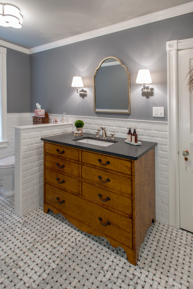 Inspiration for a country powder room in Philadelphia with furniture-like cabinets, medium wood cabinets, grey walls, ceramic floors, an undermount sink and engineered quartz benchtops.