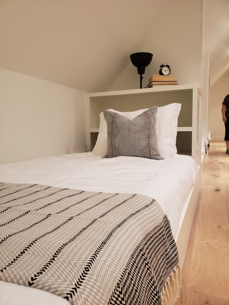 Ejemplo de dormitorio principal de estilo de casa de campo pequeño sin chimenea con paredes blancas, suelo de madera en tonos medios y suelo beige