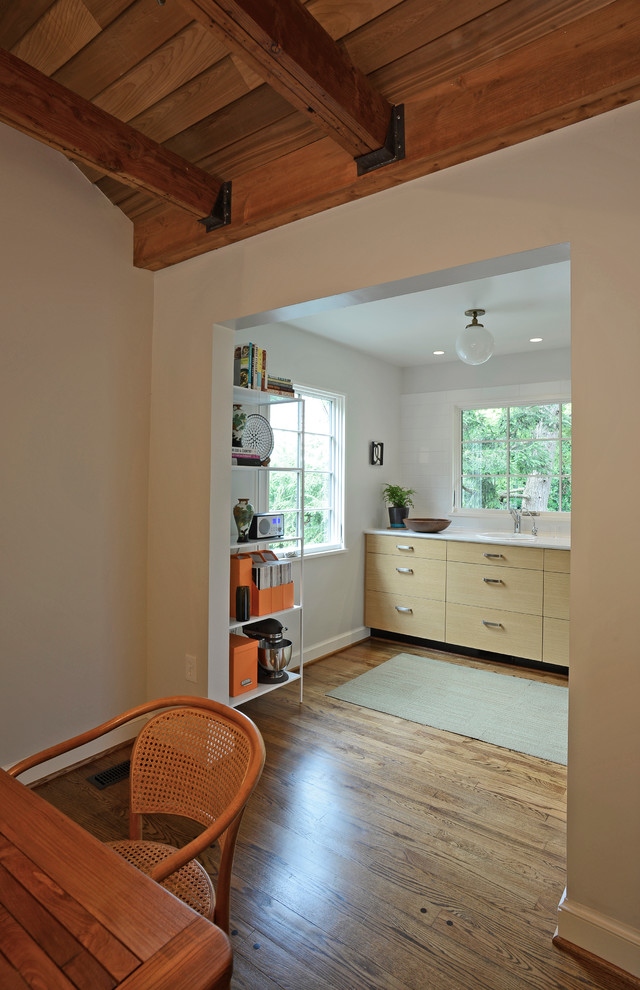 Inspiration for a mid-sized transitional galley medium tone wood floor enclosed kitchen remodel in DC Metro with a drop-in sink, flat-panel cabinets, light wood cabinets, quartz countertops, white backsplash, ceramic backsplash, stainless steel appliances and no island