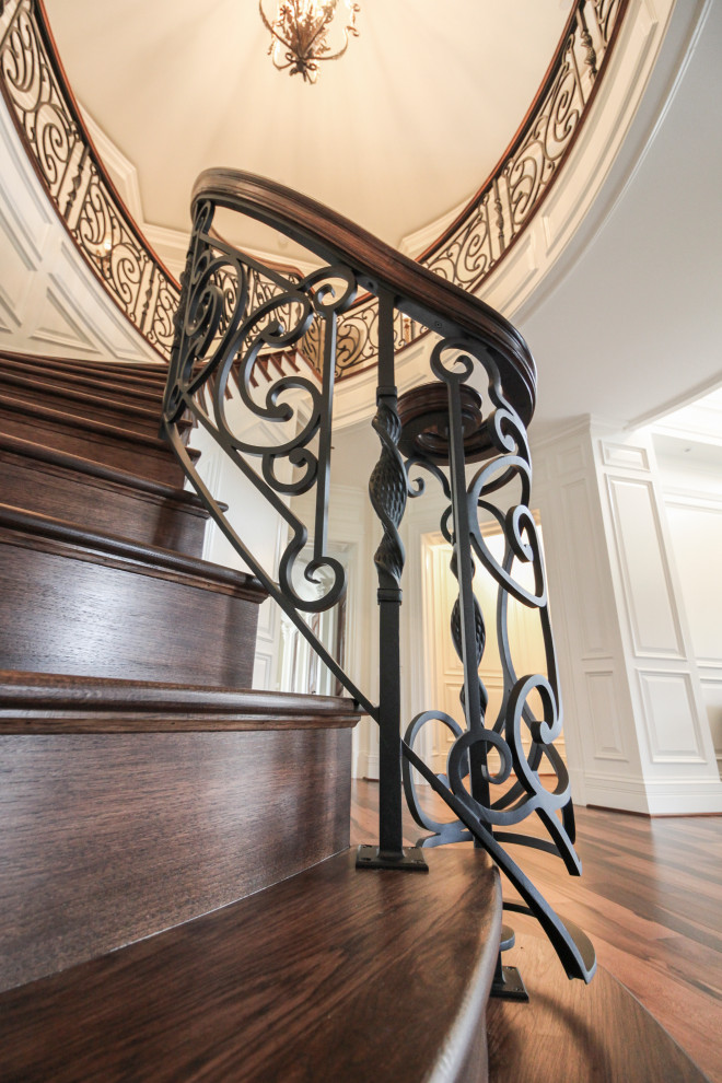 Design ideas for a large eclectic wood curved staircase in DC Metro with wood risers and mixed railing.