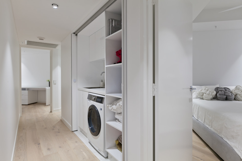 Design ideas for a small contemporary single-wall dedicated laundry room in Perth with an undermount sink, flat-panel cabinets, white cabinets, quartz benchtops, white walls and white benchtop.