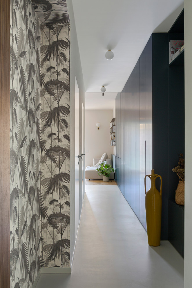 Design ideas for a mid-sized contemporary hallway in Milan with blue walls, concrete floors, grey floor and wallpaper.
