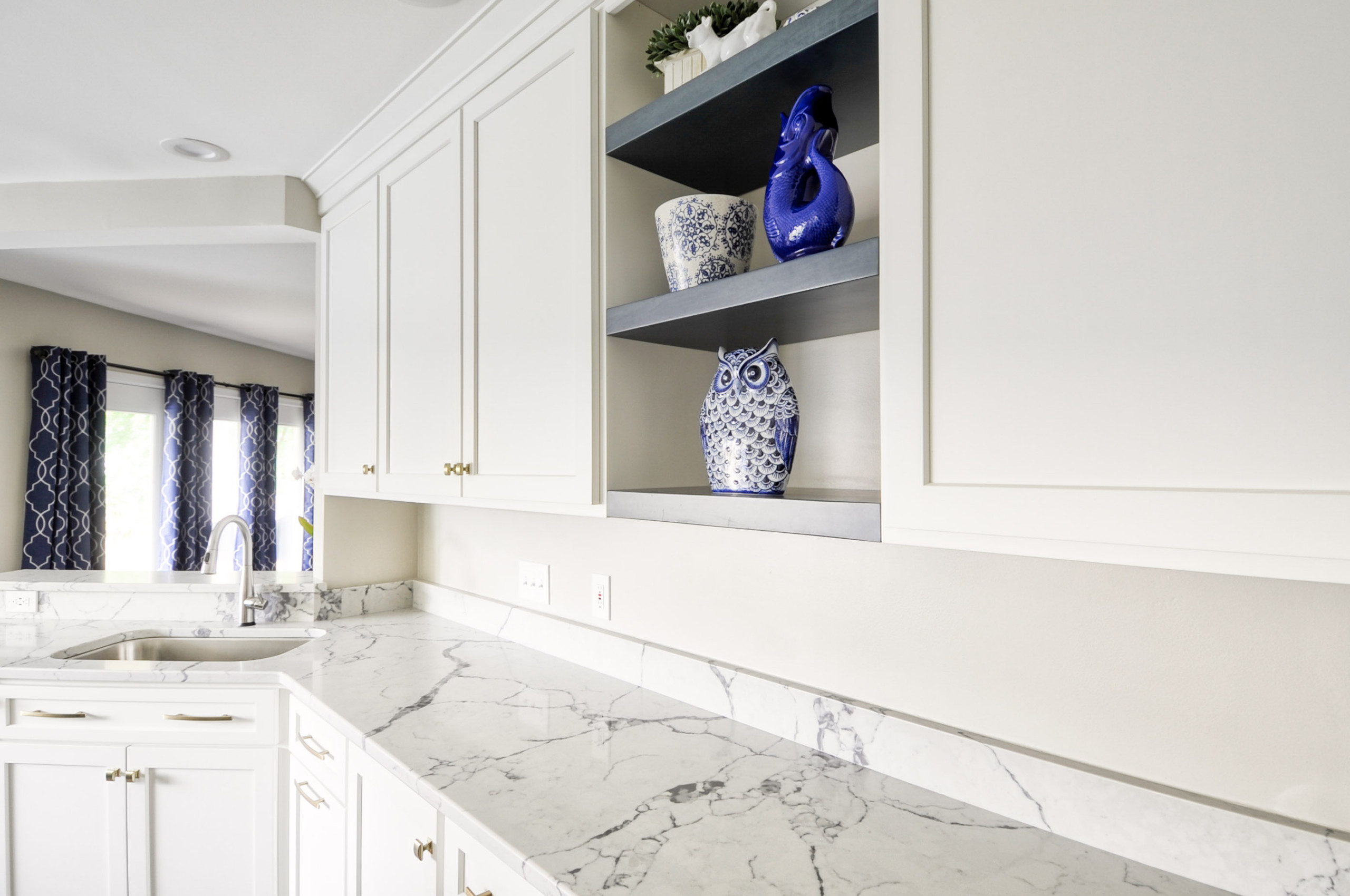 Navy Stained Island, Hood vent and Floating Shelves in White Shaker Kitchen